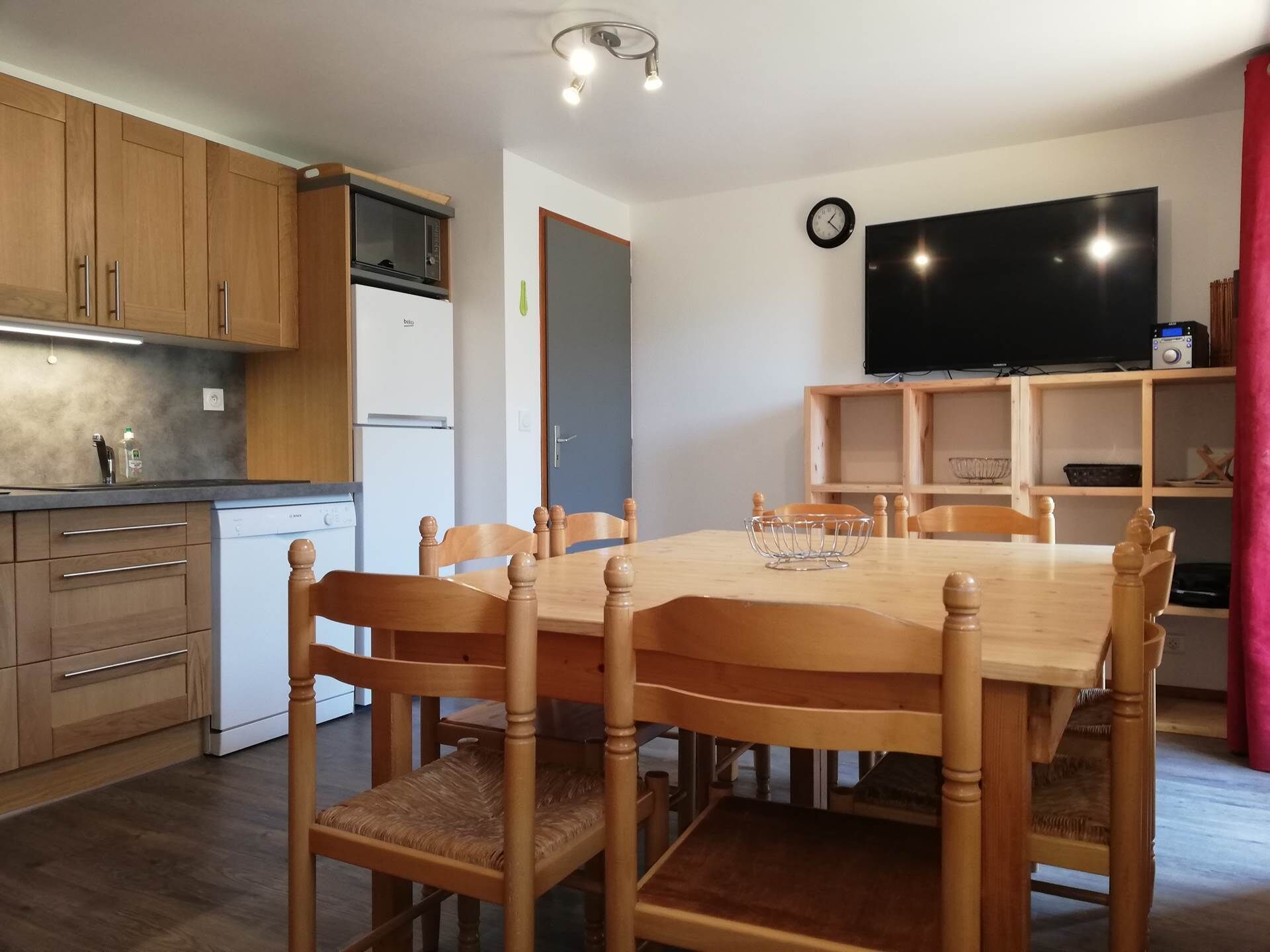 A compact kitchen with wooden cabinets, a built-in microwave, and a white refrigerator.