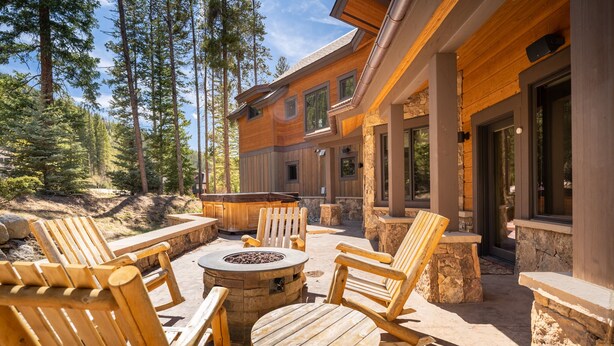 A wooden deck with outdoor seating, stone pillars, and a fire pit. - Short Walk to River Run, Private Hot Tub, Tons of Sunshine and Natural Light (Keystone)