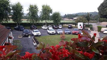 A parking lot with various cars and a person walking.