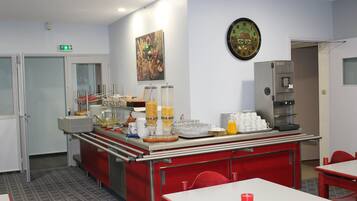 A breakfast bar with various food items and a coffee machine.
