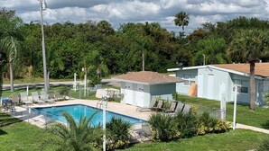 A residential area with a swimming pool, a house, and lush greenery. - Sebastian Gardens Inn & Suites (Sebastian)