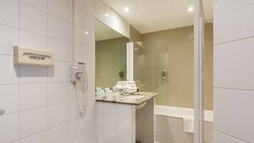 A modern bathroom with a glass shower enclosure, a built-in toilet, and a bathtub.