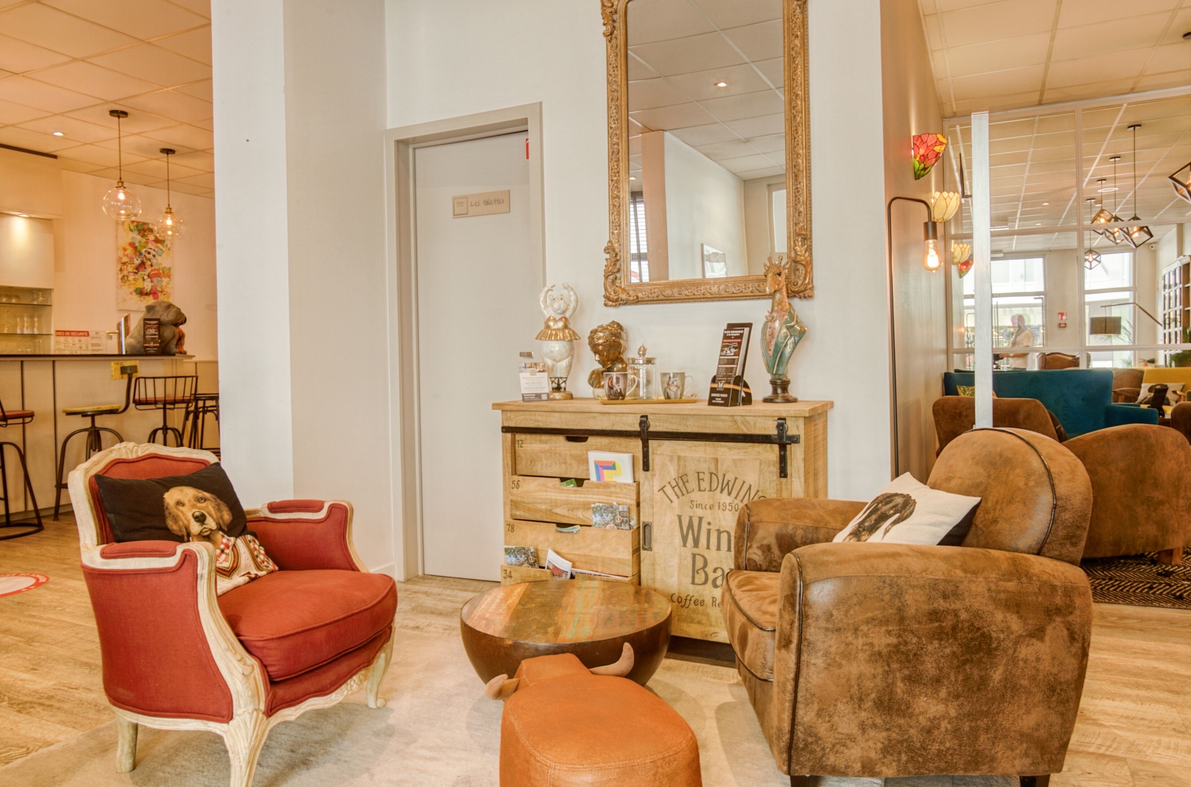 Un rincón tranquilo con muebles de estilo antiguo, una barra de café de madera y un espejo grande.