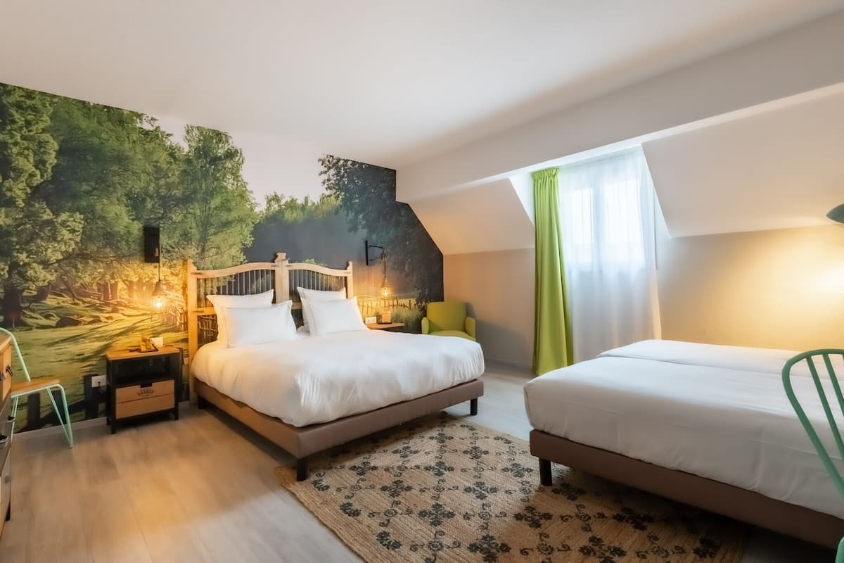 Ein Schlafzimmer mit großem Wandbild, einem Bett, einem Sessel und einem Schreibtisch.