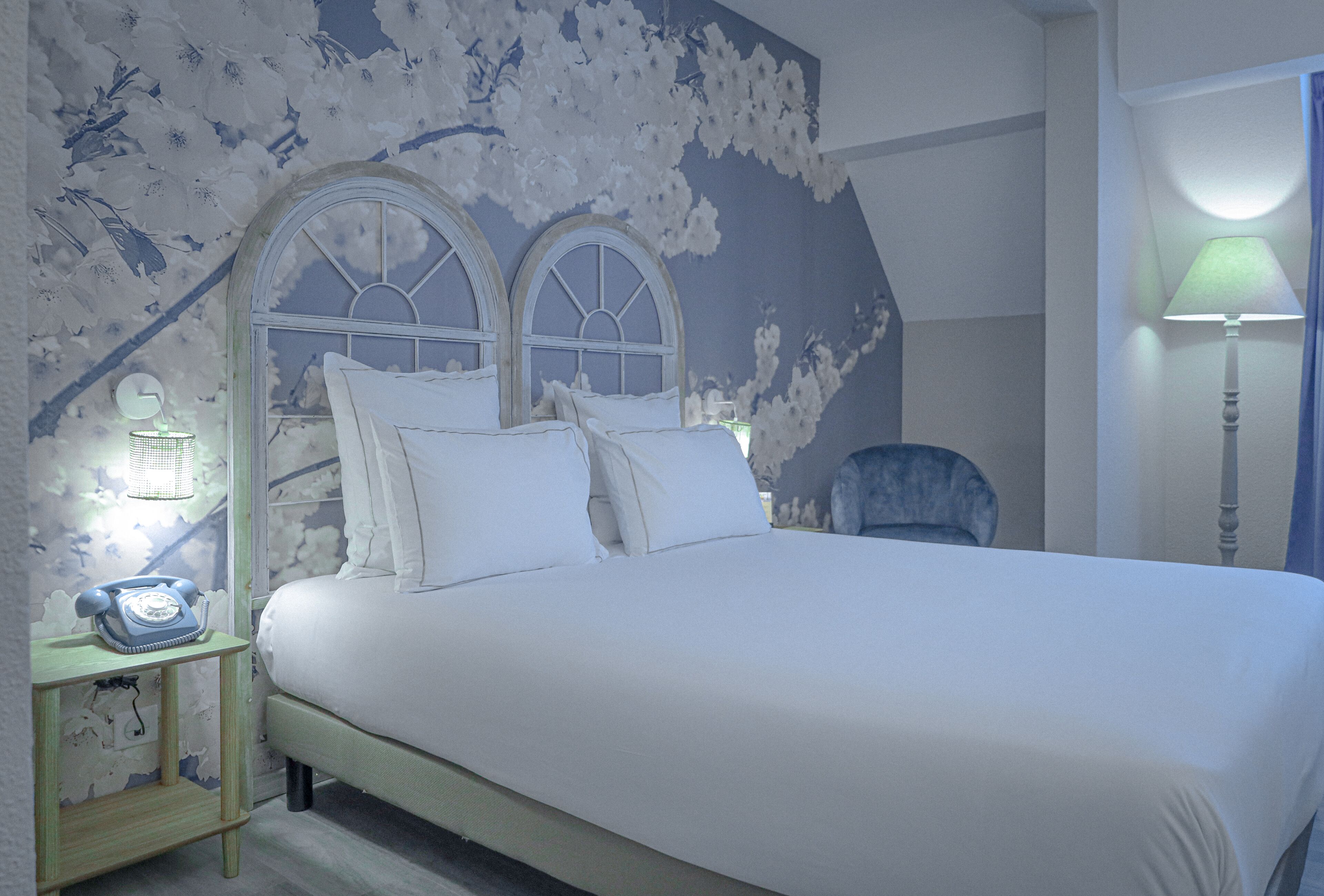 Un dormitorio con cama, mesita de noche y lámpara.