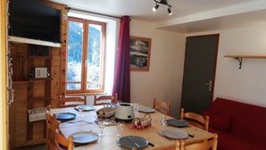 A wooden dining table set with plates, glasses, and cutlery. - Gîte 1- 8 persons- 4 bedrooms- Covered terrace (VALMEINIER)