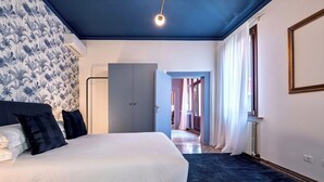A bedroom with a large bed, a wardrobe, and a door leading to another room. - The Arsenal Large Apartment (Venice)