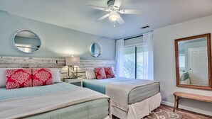 A bedroom with two beds, a ceiling fan, and a large mirror. - Quiet Beachside retreat w/ Golfcart included - close proximity to everything! (Miramar Beach)