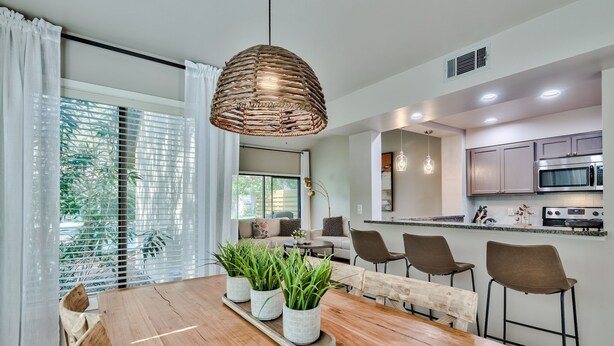 A modern kitchen with stainless steel appliances, a dining area with a wooden table and chairs, and a large window with blinds. - Quiet Beachside retreat w/ Golfcart included - close proximity to everything! (Miramar Beach)