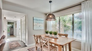 A dining area with a wooden table, chairs, and a hanging light fixture. - Quiet Beachside retreat w/ Golfcart included - close proximity to everything! (Miramar Beach)