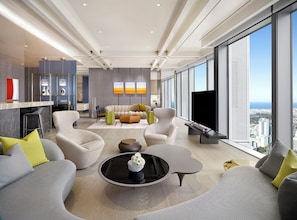 Una sala de estar moderna con un sofá, sillones, una mesa de centro y un televisor.