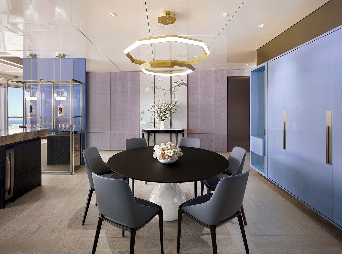A modern dining area with a round table, six chairs, and a central floral arrangement.