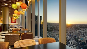 A restaurant with a city view, large windows, and hanging lanterns. - Grand Hyatt Jeju (Jeju City)