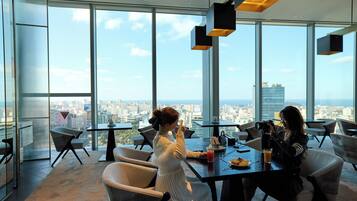 A modern dining area with large windows offering a city view.