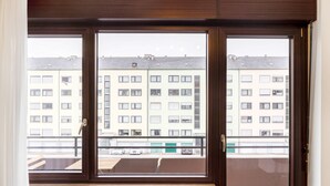 Una habitación con un amplio ventanal que da a un edificio residencial.
