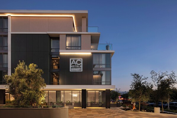 A modern hotel with a flat roof, large windows, and a well-lit entrance. - AC Hotel by Marriott Palo Alto (Palo Alto)