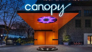 Un bâtiment orné d’une enseigne au néon sur laquelle on peut lire le mot « canopée » et doté d’une vitrine circulaire.