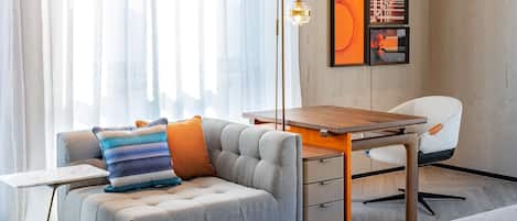 Una sala de estar moderna con un sofá, una mesa de centro de madera y una lámpara de pie.