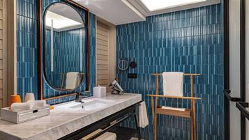 A modern bathroom with a large mirror, a sink, and a towel rack.