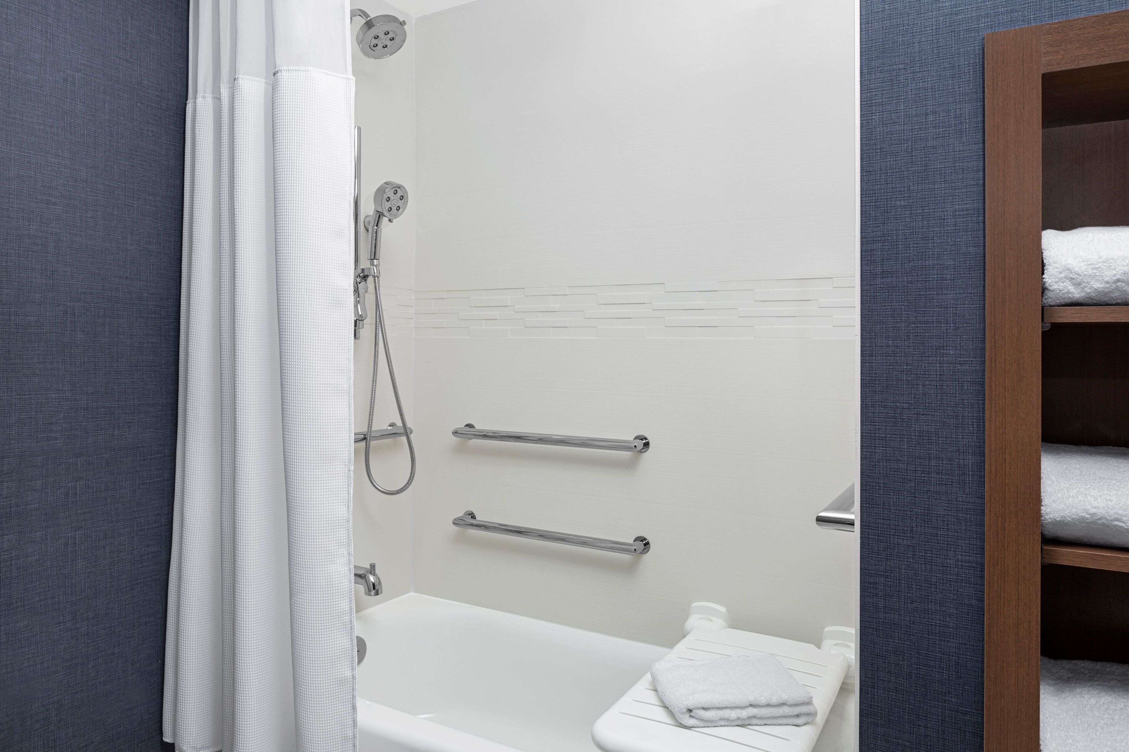 Ein modernes Badezimmer mit Dusche, Toilette und Handtuchhalter.