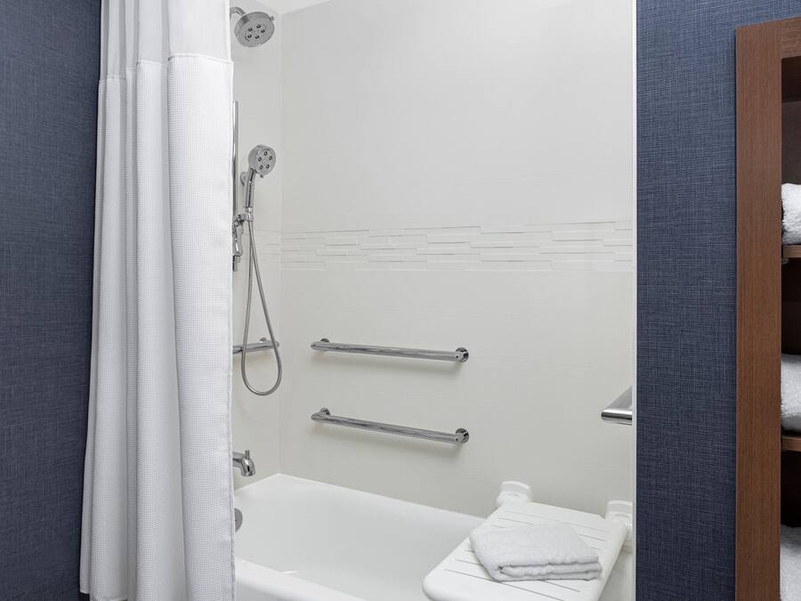 Ein modernes Badezimmer mit Dusche, Toilette und Handtuchhalter.