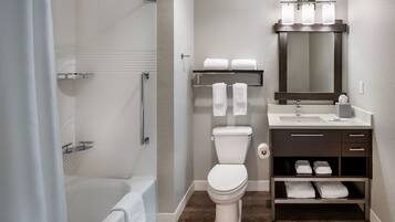 A modern bathroom with a bathtub, toilet, and vanity.