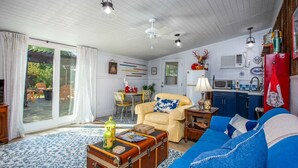 A cozy living room with a sofa, a coffee table, and a dining area with a table and chairs.