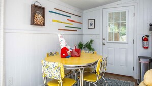 A dining area with a round table, yellow chairs, and a white door with a window.