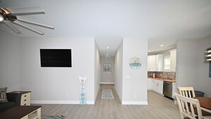 A modern apartment with a living room, kitchen, and hallway. - Seaglass Cottages (calabash)