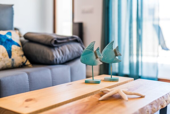 Een houten tafel met een zeester decoratie en twee sculpturen in de vorm van vissen.
