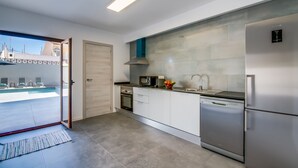 Une cuisine moderne équipée d’un four, d’un micro-ondes et d’un lave-vaisselle intégrés.