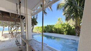 A wooden deck with a hot tub and swings overlooking a pool and beach. - Pink Flamingo Beach House Private Beachfront Paradise with Pool Sleeps 12 (North Captiva)