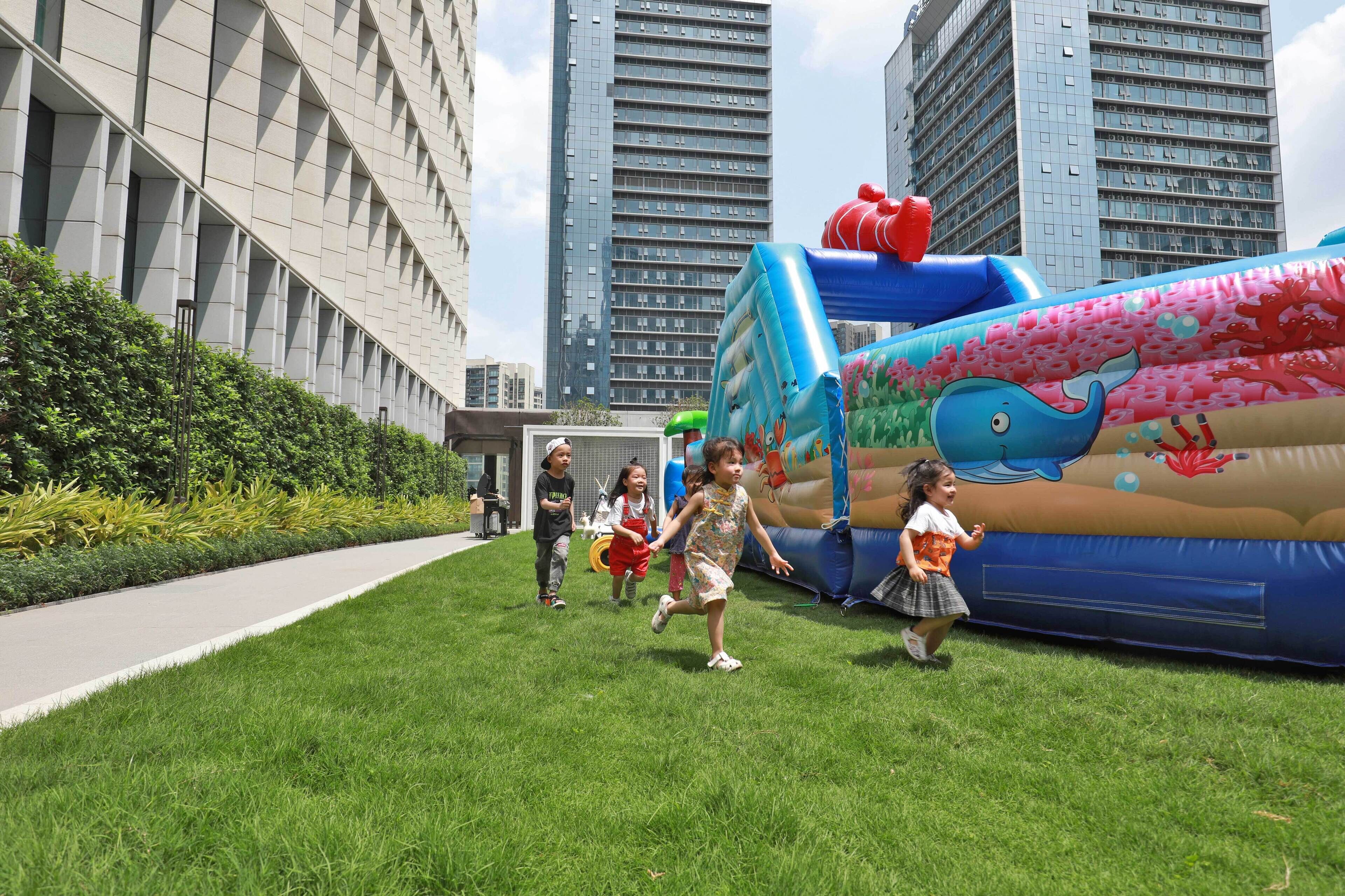 A grassy area with a large inflatable structure featuring a whale design.
