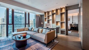 A modern hotel room with a large sofa, a coffee table, and a view of the cityscape. - InterContinental Foshan Dongping Hotel by IHG (Foshan)