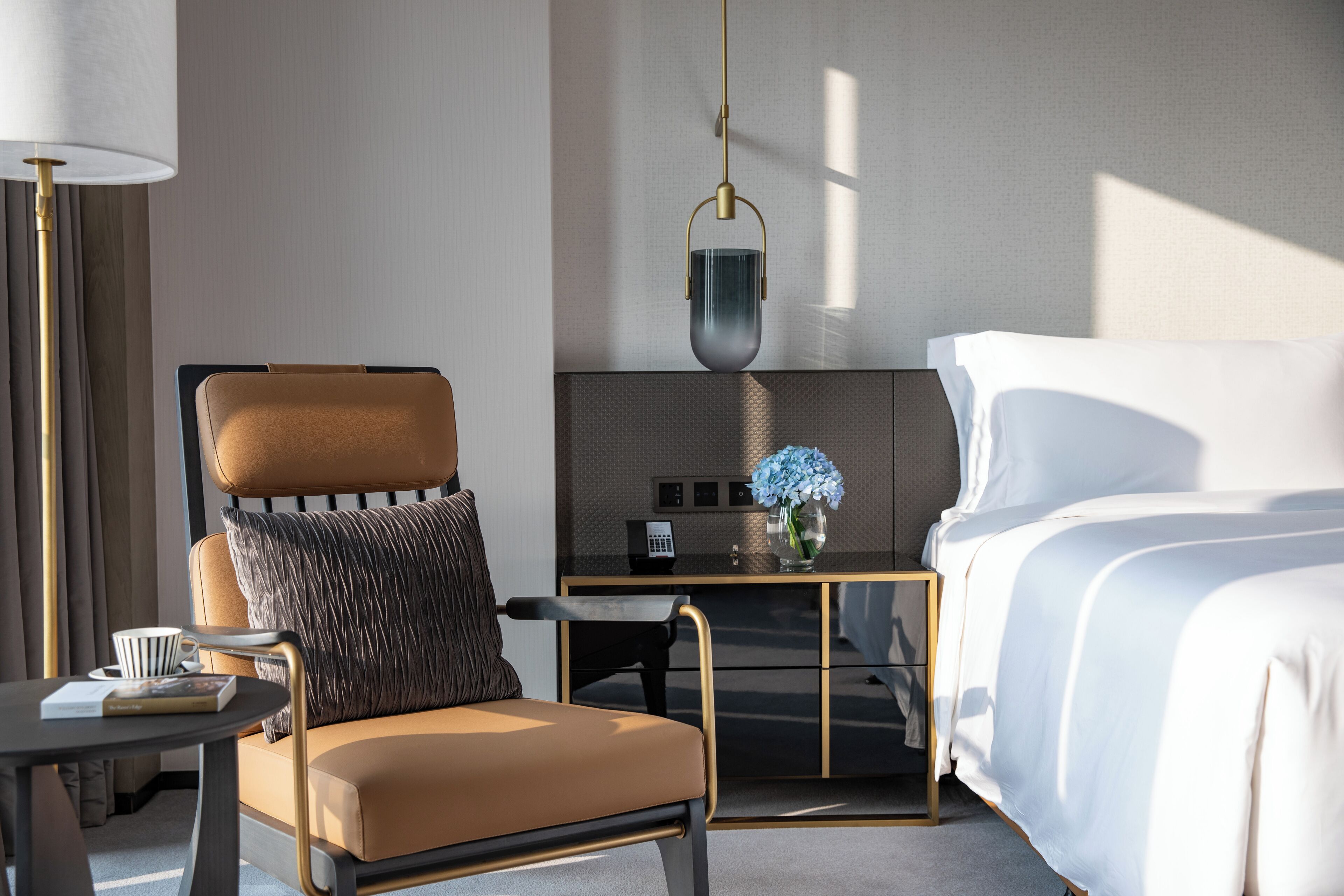 Una habitación de hotel moderna con cama, sofá, escritorio y lámpara.