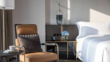 Una habitación de hotel moderna con cama, sofá, escritorio y lámpara.