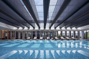 Piscine couverte, piscine extérieure, parasols de plage, chaises longues