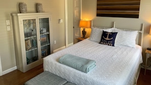 A neatly arranged bedroom with a bed, bedside lamp, and a ceiling fan. - Amazing WEST END location, steps away from all the action! (Provincetown)