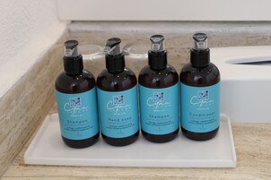 Cuatro botellas de productos Cayan Cancún sobre una bandeja blanca.