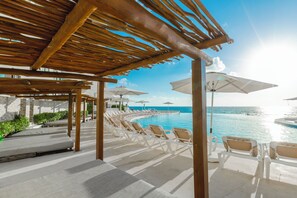 Una piscina al aire libre, camas de piscina gratis, sombrillas