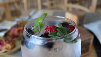 Un vaso con hielo, hojas de menta y bayas.