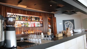 A bar area with a variety of liquor bottles, a coffee machine, and neatly arranged glasses. - Cyan Cancun Resort & Spa  (Cancun)