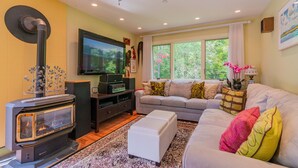 A living room with a fireplace, sofa, and television. - Theatre in the Wood Too! - I’m the fancy sister (Stowe)