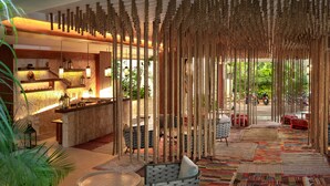 A spacious indoor area with a bar, seating, and a view of the outdoors. - Sunday Hotel Naala Tulum (Tulum)