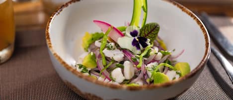 Un'insalata in una ciotola con diversi ingredienti e un fiore decorativo sopra.