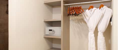 Een inloopkast met houten planken en een kledingrek.