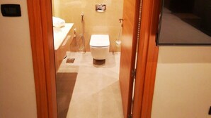 A modern bathroom with a toilet, bidet, and sink.