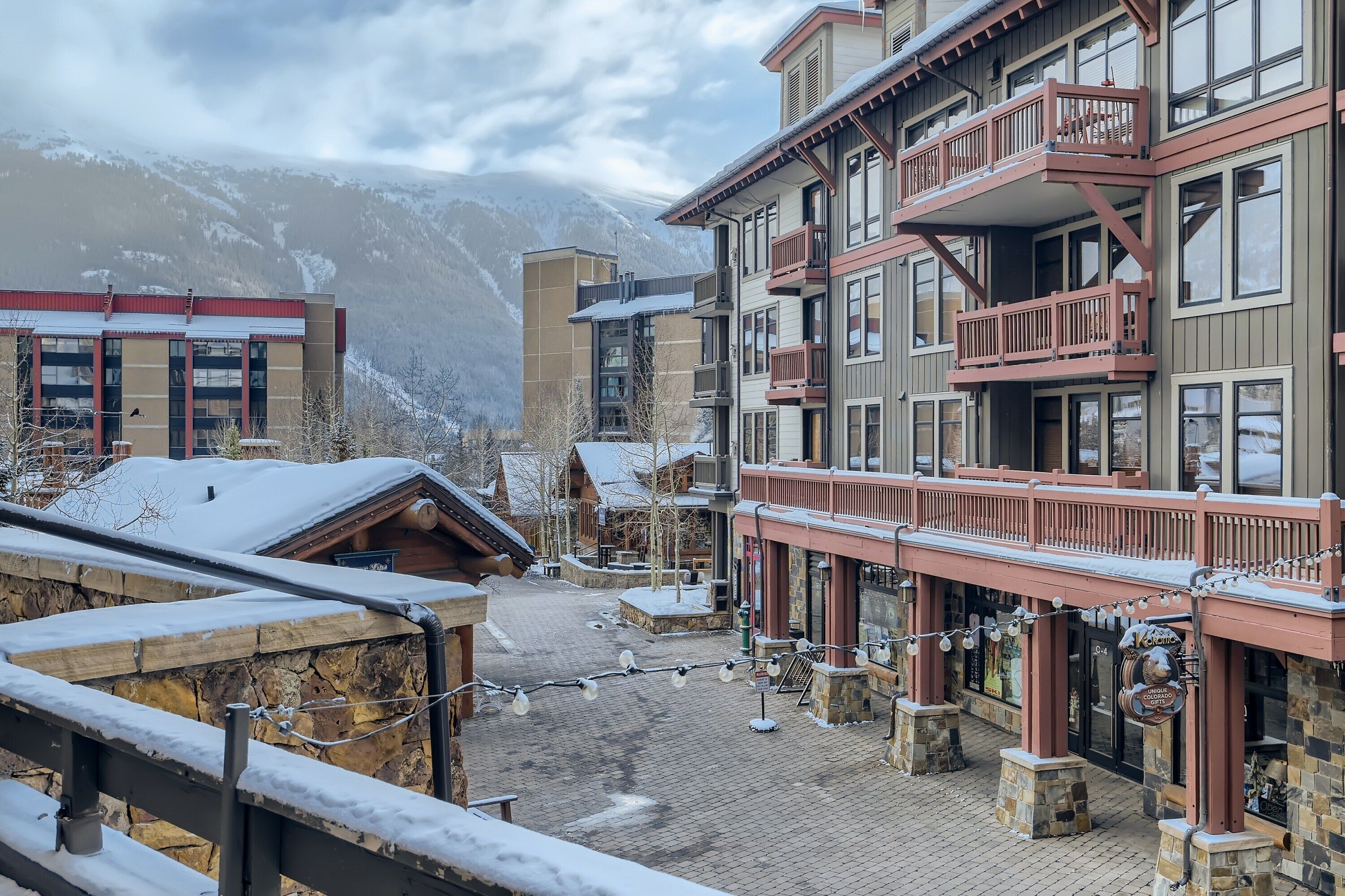A snow-covered building with a balcony and a sign that reads "The Lodge".