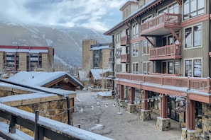 Um edifício coberto de neve com uma varanda e um letreiro que diz 'The Lodge'.