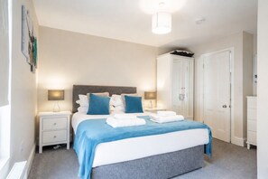 A bedroom with a bed, bedside tables, a wardrobe, and a ceiling light. - 49 Scott Street -  a family break that sleeps 6 guests  in 3 bedrooms (York)